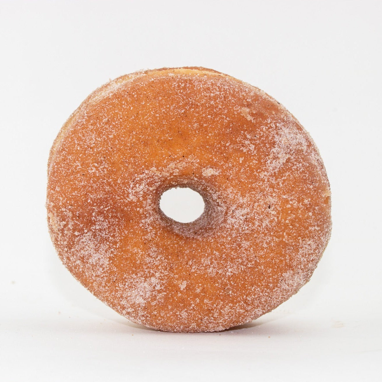 image of whole cinnamon and sugar dusted doughnut with a hole in the middle 