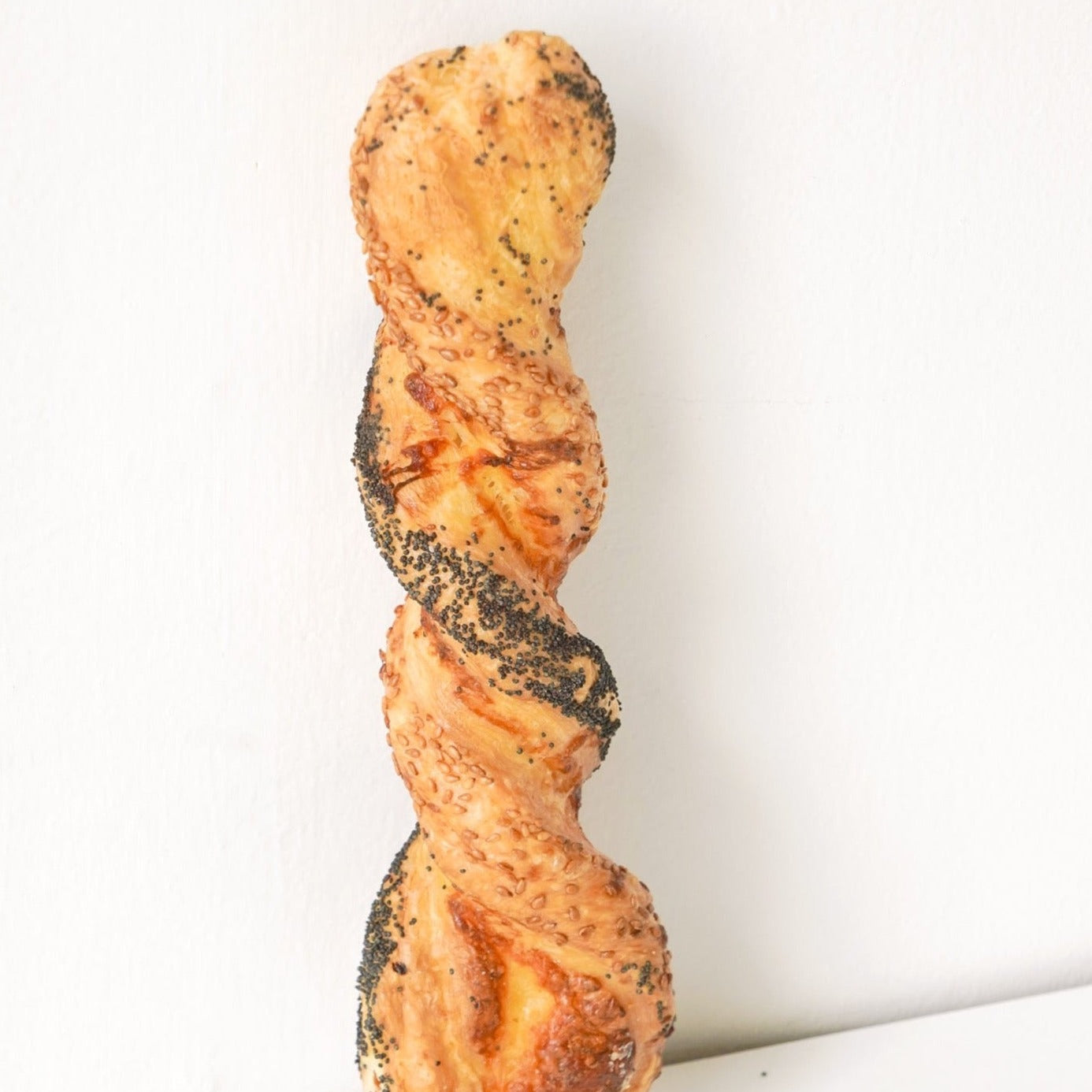 image of a cheese and black sesame pastry that has been twisted