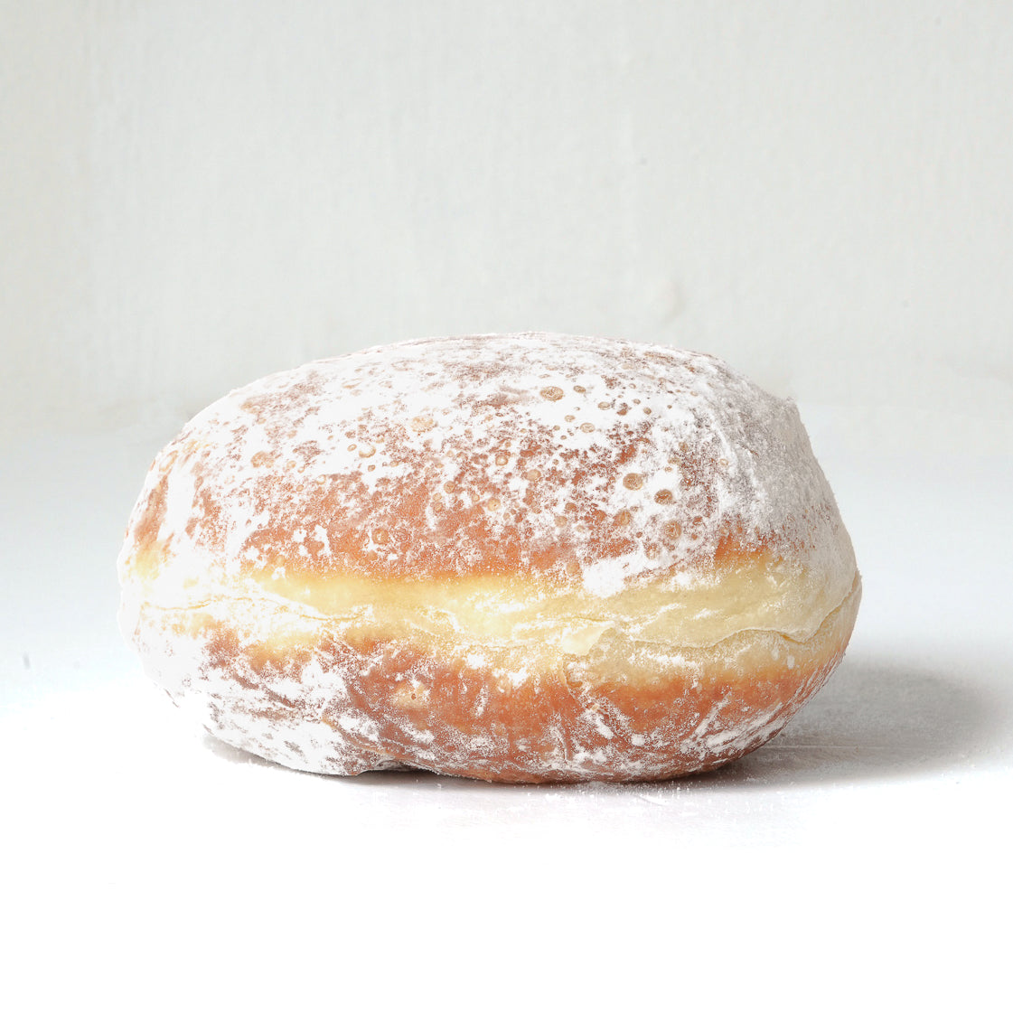image of a whole doughnut covered in a white sugar icing