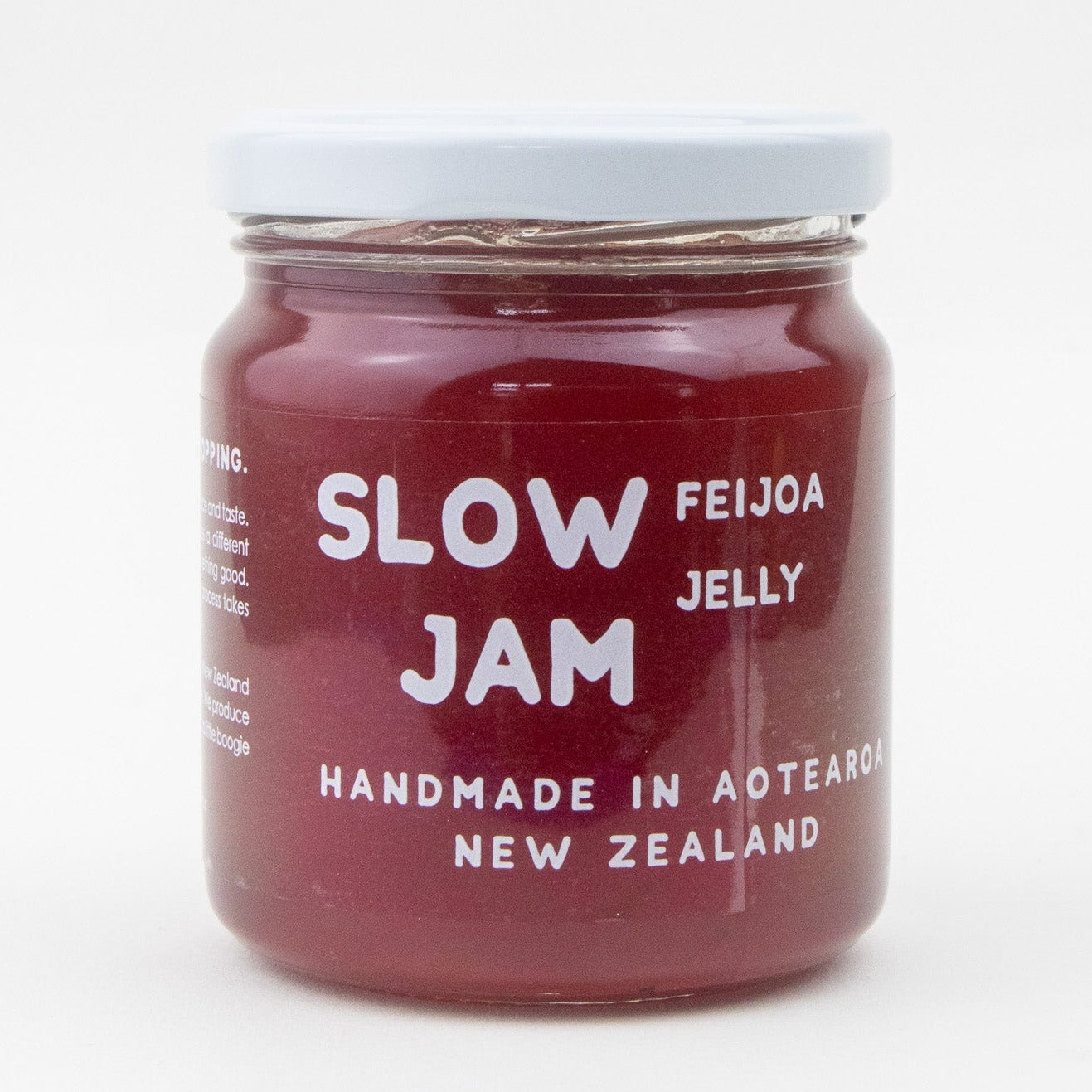 Image of a clear jar with white lid and writing. the text states that the jar is full of red handmade feijoa jam 