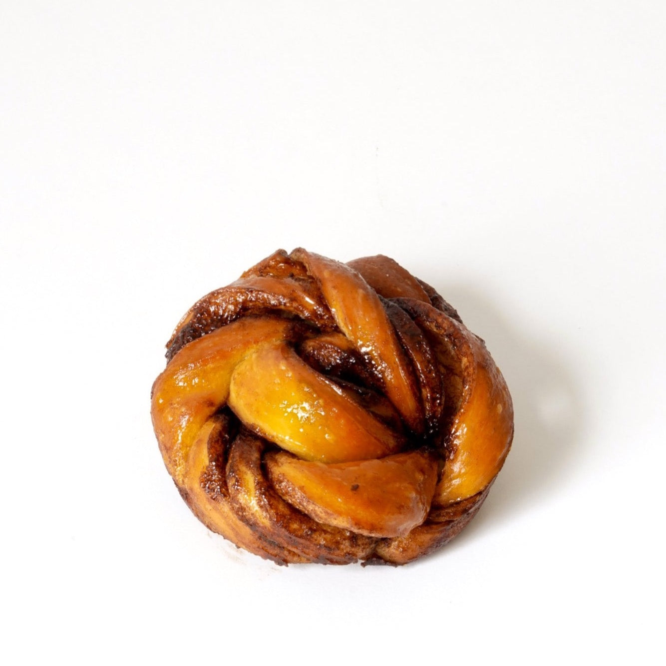 image of a knotted brown and shiny cinnamon bun 