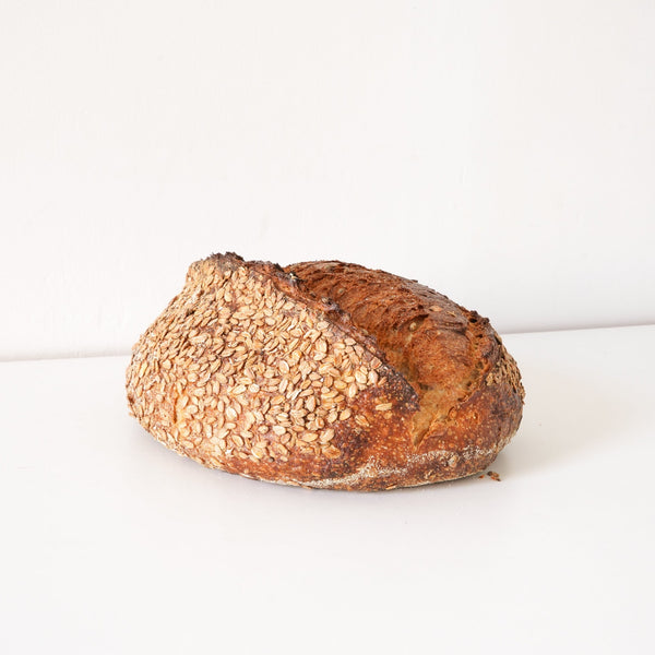 image of a golden brown loaf that is covered in smoked bye berries 