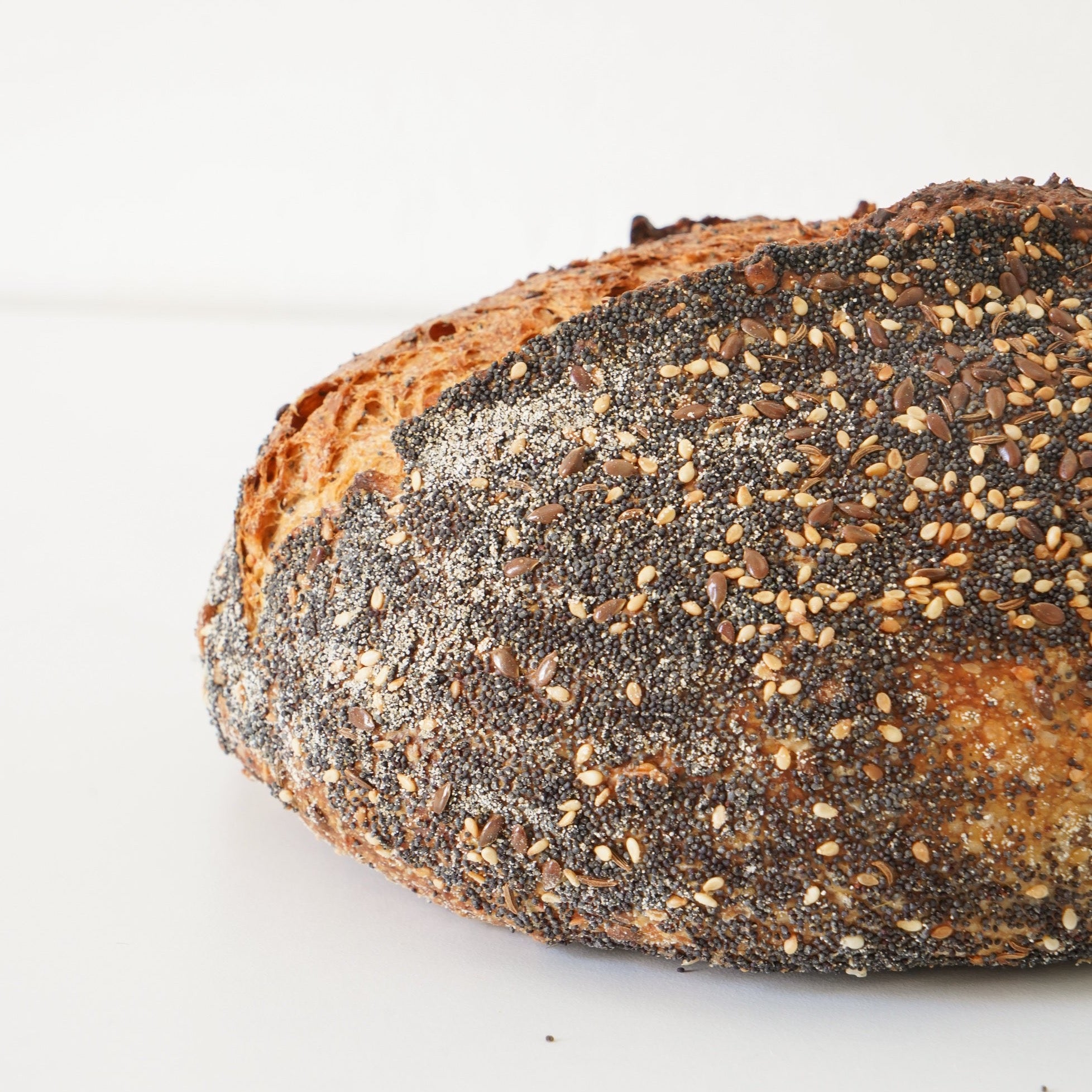Close up image of the seeded loaf. it has whole sunflower, caraway, sesame, pumpkin and poppy seeds.