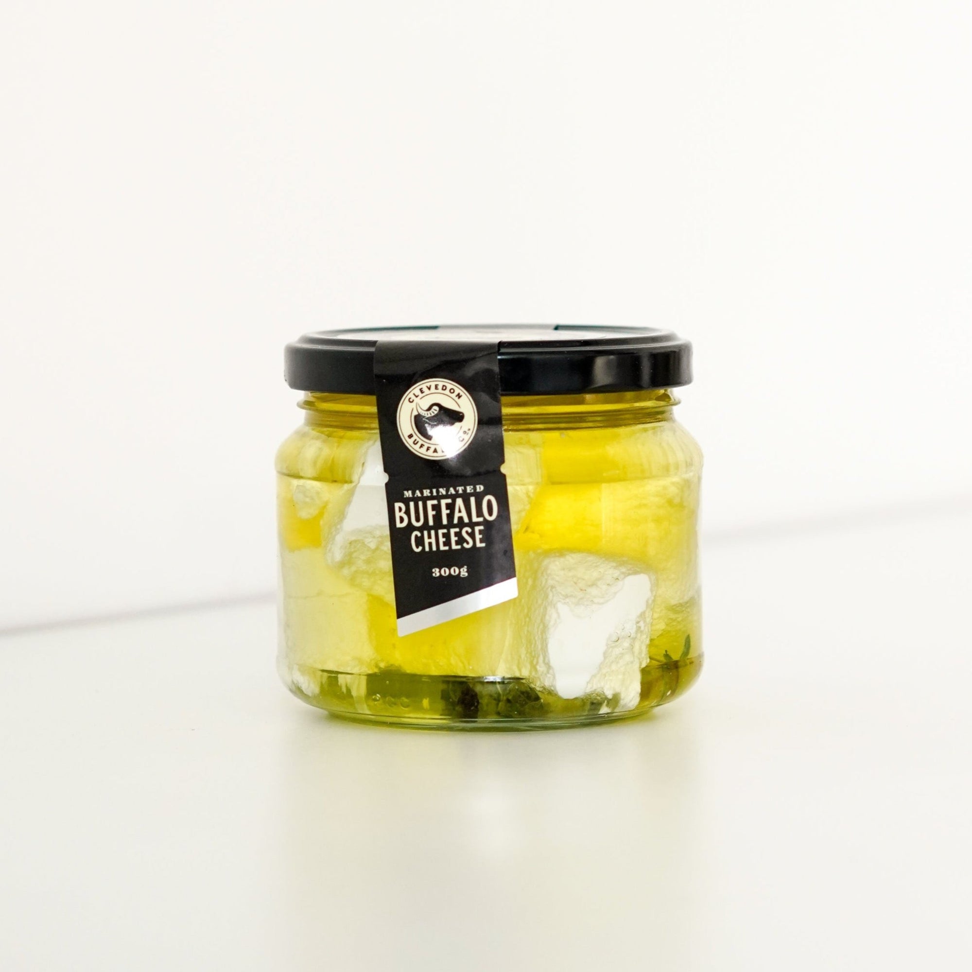 image of jar filled with buffalo cheese and oil. The jar has a black lid